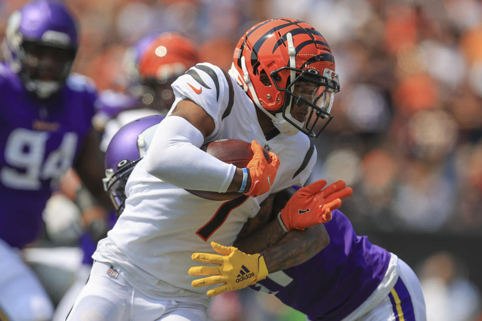 Cincinnati Bengals wide receiver Ja'Marr Chase (1) runs as Minnesota Vikings defensive back Bashaud Breeland tries to tackle him in the first half of an NFL football game, Sunday, Sept. 12, 2021, in Cincinnati. (AP Photo/Aaron Doster)