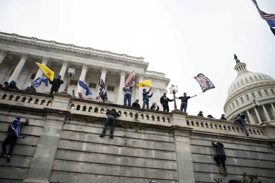 FILE - In this Wednesday, Jan. 6, 2021, file photo, supporters of President Donald Trump climb the west wall of the the U.S. Capitol on in Washington. Lies, misinformation and conspiracy theories related to the 2020 election are gaining traction among local, county and state Republicans, who are using their online platforms to disseminate many of the same dangerous messages that led to the violent insurrection at the Capitol last month. (AP Photo/Jose Luis Magana)