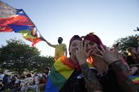 Members of the Movement for Homosexual Integration and Liberation celebrate after lawmakers approved legislation legalizing marriage and adoption by same-sex couples, in Santiago, Chile, Tuesday, Dec. 7, 2021. (AP Photo/Esteban Felix)