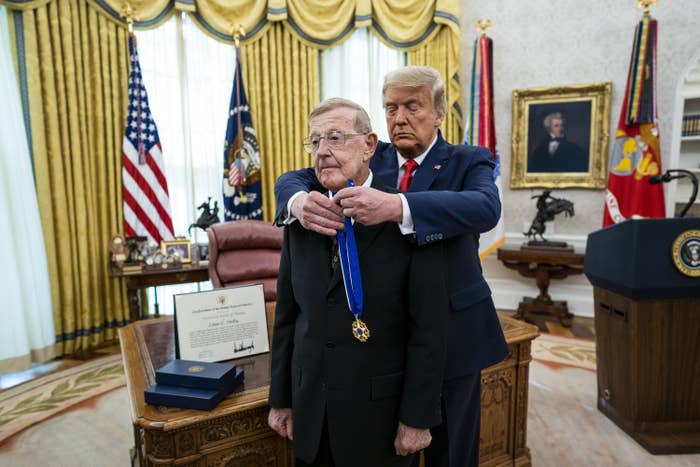 Former President Trump placing a medal around a man's neck