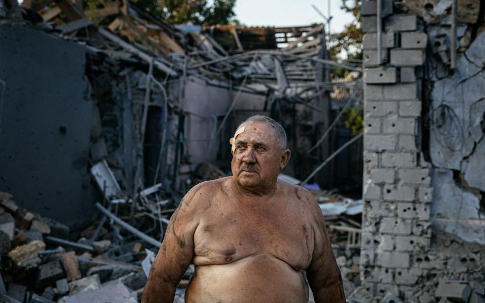 Oleksandr Shulga stands in front of his destroyed house following a missile strike in Mykolaiv - DIMITAR DILKOFF/AFP