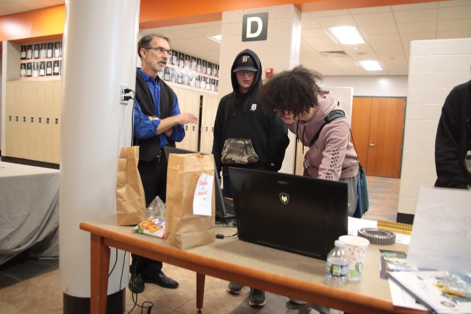 Cliff Middleton of General Broach in Morenci, left, talks about careers the company offers while juniors Tyler London and Hayden Grimes try out the design software the company uses during the Career Exploration Fair Wednesday at the school.