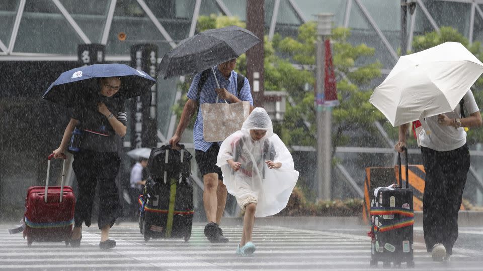 People buffeted by rain in Nagoya City, Aichi Prefecture on Tuesday. - Koji Ito/The Yomiuri Shimbun/AP