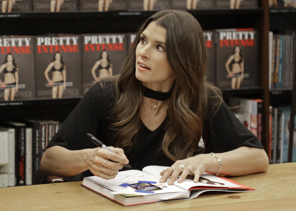 Danica Patrick talks to a fan as she autographs her new book during a book signing in Charlotte, N.C., Thursday, Jan. 4, 2018. The transition from race car driver to businesswoman was swift, and Patrick is now adjusting to a new celebrity life that doesnt include driving cars. (AP Photo/Chuck Burton)