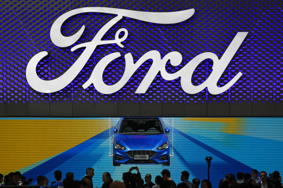 FILE- In this April 25, 2018, photo, visitors and journalists gather near a Ford Focus on display at the Ford exhibit during the media day for the China Auto Show in Beijing. Ford reports earnings on Tuesday, Feb. 6, 2024. (AP Photo/Andy Wong, File)