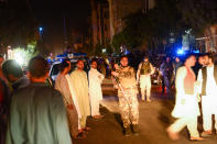 <p>Armed Afghan security personnel (C and Rear R) walk past people reacting on the street, following a suicide bomb attack at a Shiite mosque in Herat on August 1, 2017. (Photo: Hoshang Hashimi/AFP/Getty Images) </p>