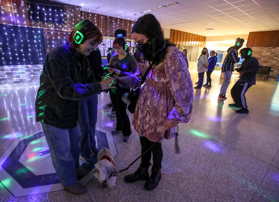 Emerson Tuttle helps Lila Coburn figure out the headphones at J. Graham Brown School's first silent disco.