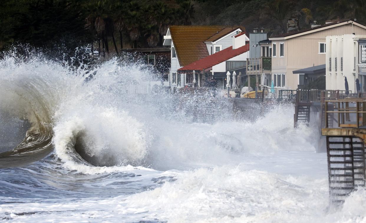 Powerful waves crash next to homes along the coastline on December 30, 2023 in Ventura, California.