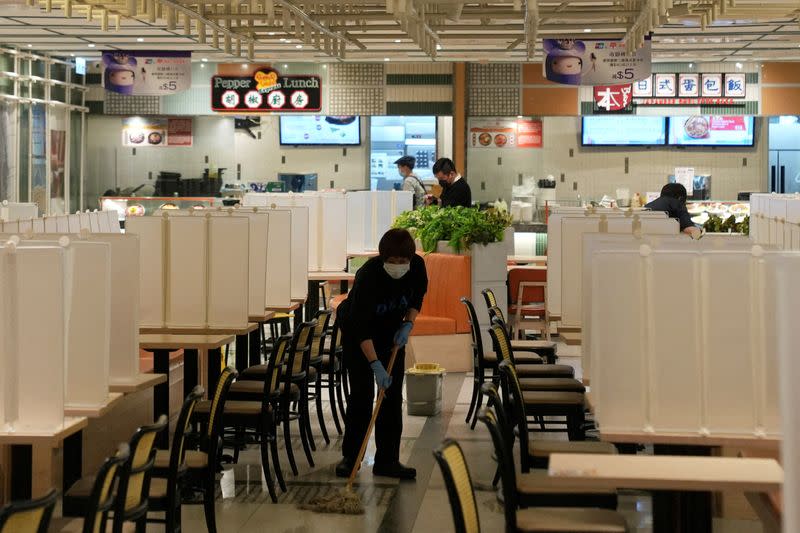 FILE PHOTO: Staff member wipes the floor at an empty food court in Hong Kong