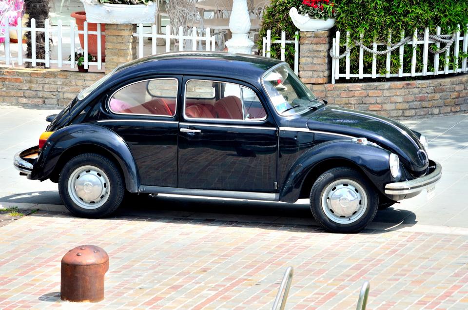 [UNVERIFIED CONTENT] The Volkswagen Beetle, officially called the Volkswagen Type 1 (or informally the Volkswagen Bug), is an economy car produced by the German auto maker Volkswagen,from 1938 until 2003. In 1973, the VW 1303 introduced a curved windscreen, pushed forward and away from the passengers, allowing a redesigned, padded dashboard to replace the pre-1973 vertical dash. A two-speed heater fan, higher rear mudguards, and larger tail lights were added. The changes to the heater/windshield wiper housing and curved windshield resulted in slight redesign of the front hood, making the 1971 and 1972 Super Beetle hoods unique. In late 1973, the well-equipped "1303/Big" special edition was introduced as customers were looking for less spartan cars. These have 15-inch wheels, metallic paintwork, a more luxurious interior, a heated rear windshield, and some other comforts.