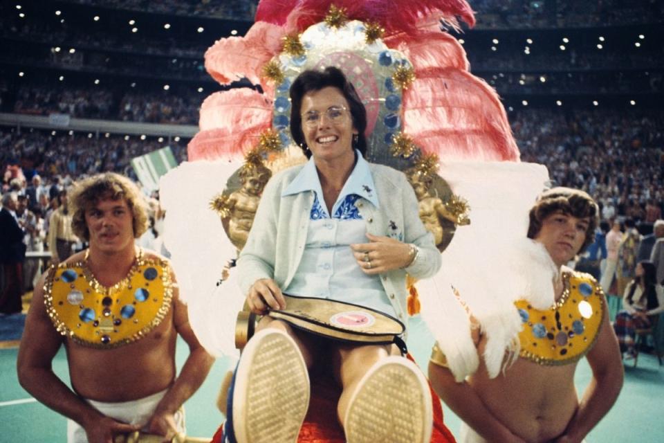 Billie Jean King on gold throne carried by men dressed as ancient slaves. Source: Getty Images