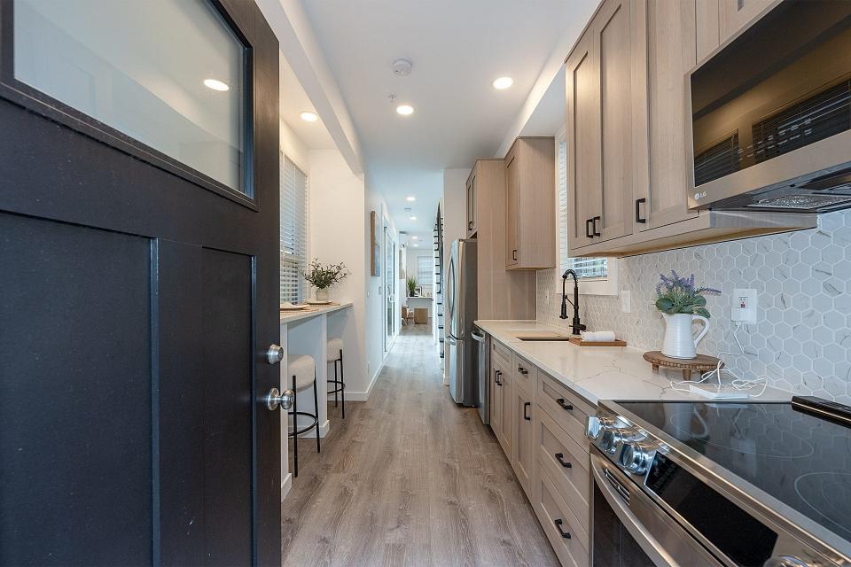 The front entrance and kitchen of a skinny home.