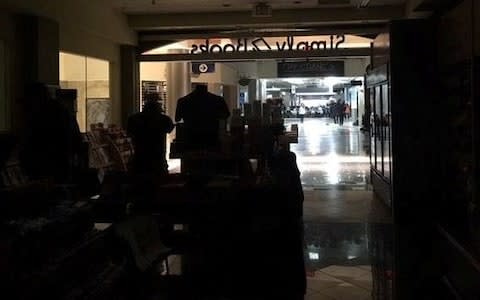 Air passengers navigate their way through darkened corridors at Atlanta airport - Credit: APLINETREEE/Instagram/Reuters