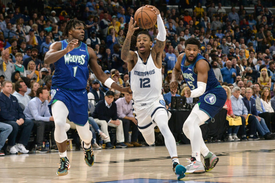 Memphis Grizzlies guard Ja Morant (12) drives between Minnesota Timberwolves forward Anthony Edwards (1) and guard Malik Beasley (5) during the first half of Game 1 of a first-round NBA basketball playoff series Saturday, April 16, 2022, in Memphis, Tenn. (AP Photo/Brandon Dill)