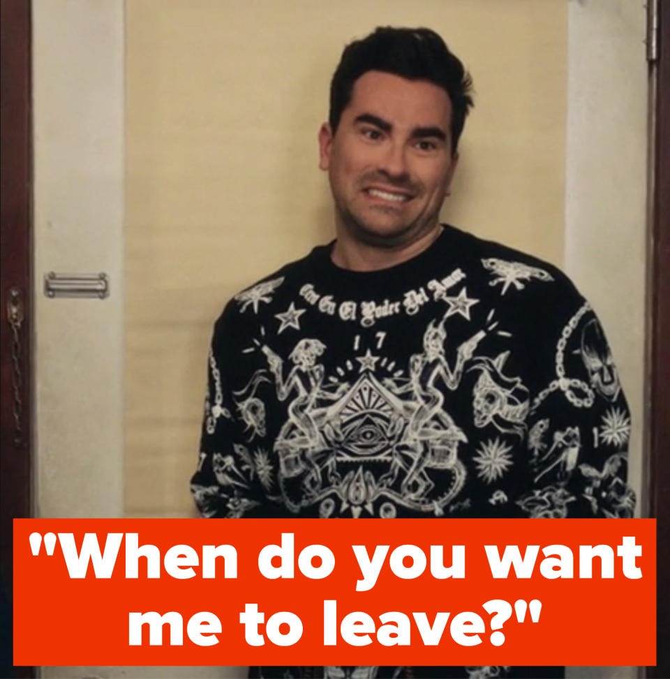 Dan Levy stands against a backdrop, wearing a black sweater with elaborate white designs. Text "#SchittsCreek" and CBC logo are in the corner