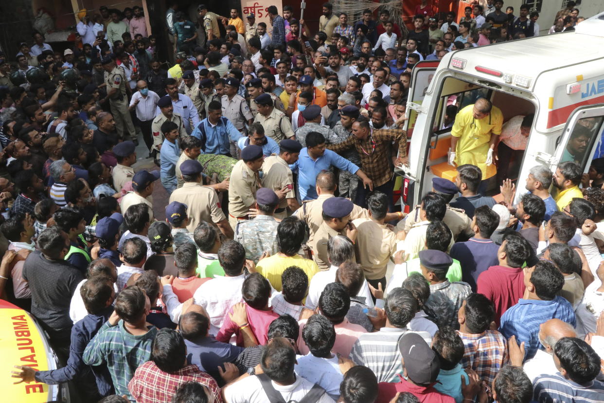 An accident victim is carried towards a waiting ambulance in Indore, India, Thursday, March 30, 2023. A structure built over an old temple well in India collapsed Thursday as a large crowd of devotees prayed at a festival for Rama, one of the most widely worshipped Hindu deities, killing at least eight people, police said. (AP Photo)