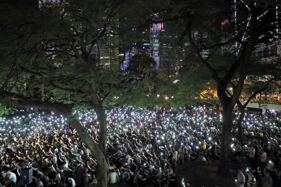 Attendees hold up their lit mobile phones during a rally by mothers in Hong Kong on Friday, July 5, 2019. Hong Kong's societal divide showed no sign of closing Friday as students rebuffed an offer from city leader Carrie Lam to meet and a few thousand mothers rallied in support of young protesters who left a trail of destruction in the legislature's building at the start of the week. (AP Photo/Kin Cheung)