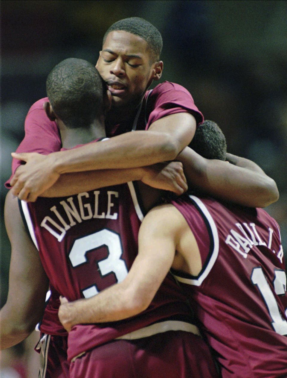 FILE - Massachusetts' Marcus Camby hugs teammates Dana Dingle (3) and Edgar Padilla (12) late in the second half as they beat top ranked Kentucky in their Great Eight Invitation game in Auburn Hills, Mich., Tuesday, Nov. 28, 1995. (AP Photo/Timothy Fitzgerald, File)