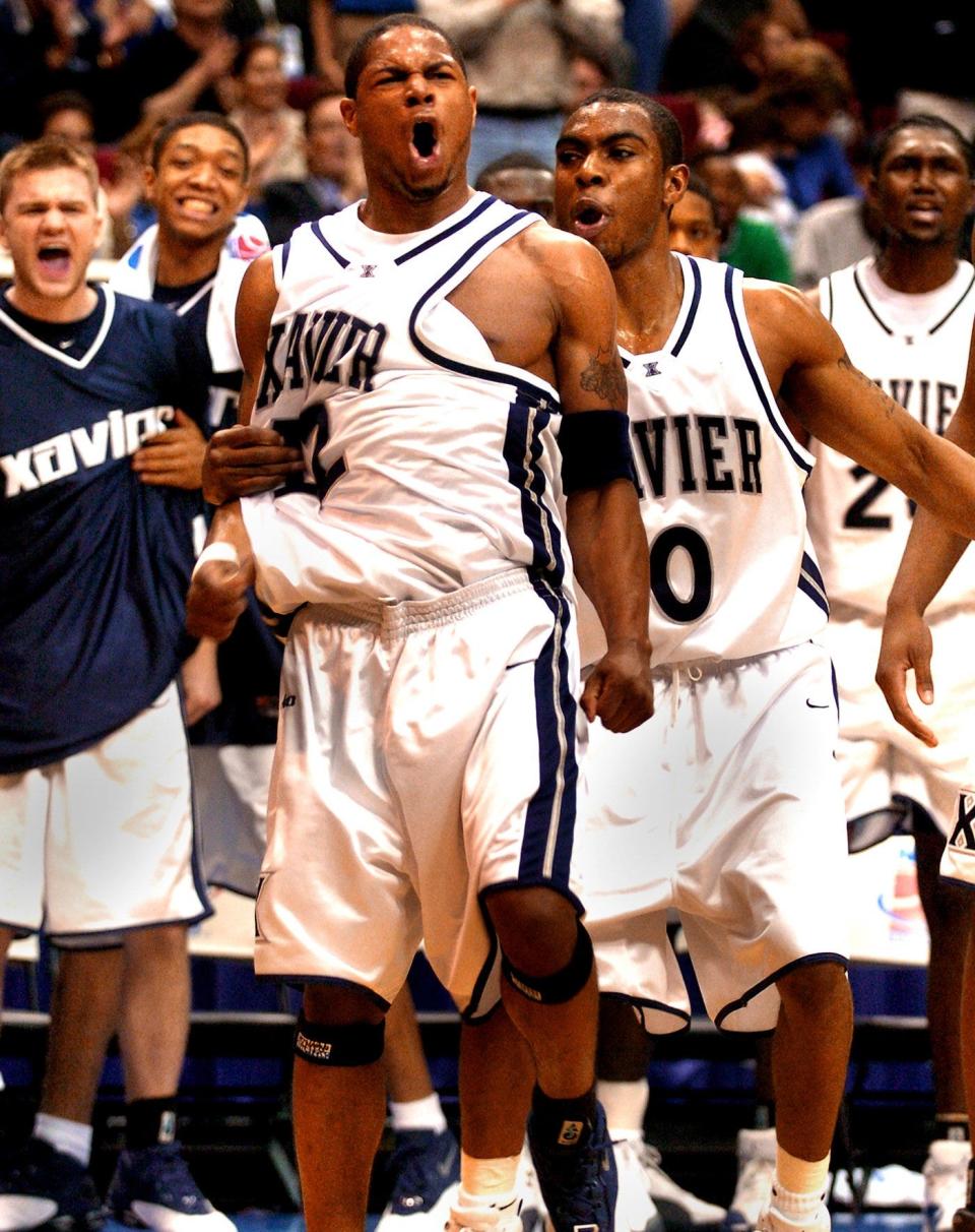 2004.0319.10.1--XAVIER VS. LOUISVILLE--Xavier's Dedrick Finn screams out as he hugged by Lionel Chalmers after Finn made a 3-point shot and was fouled as Xavier beggan to destroy Louisville in the second half Friday, March 19, 2004, in the 1st round of the NCCA championship in Orlando Florida at the T. D. Waterhouse Centre.