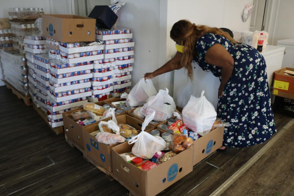 Jeannette Best, founder of A Hand Up International, prepares boxes Aug. 19 for the next food drive. The organization will host its inaugural Speed for those in Need 5K Run on Sept. 17.