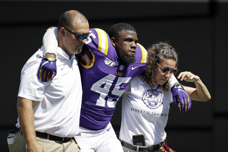 LSU linebacker Michael Divinity Jr. (45) is helped off the field after being injured in the first half of an NCAA college football game against Vanderbilt Saturday, Sept. 21, 2019, in Nashville, Tenn. (AP Photo/Mark Humphrey)