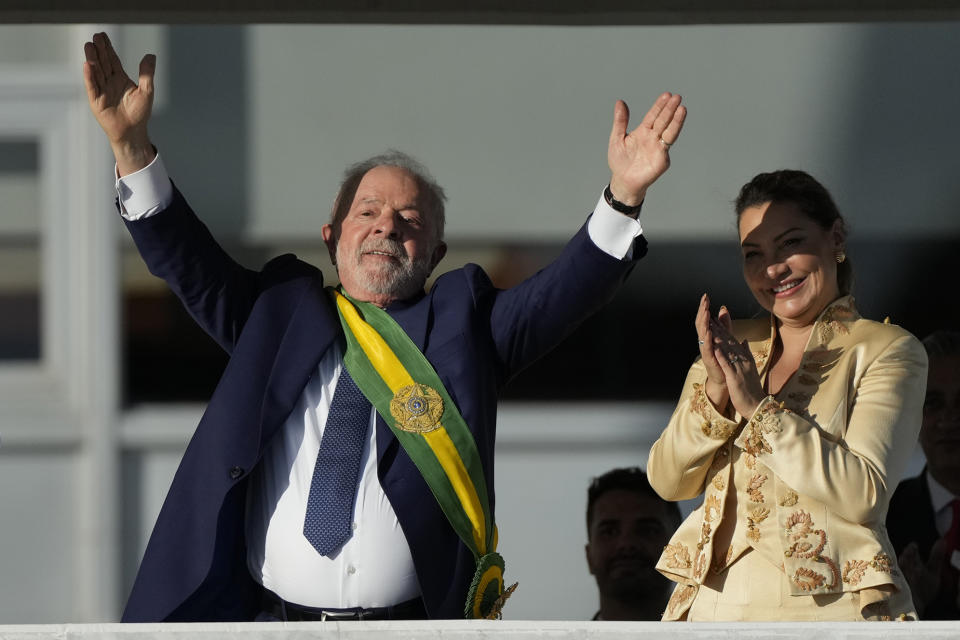 President Luiz Inacio Lula da Silva, left, waves to supporters beside his wife Rosangela Silva after he was sworn in as new president at the Planalto Palace in Brasilia, Brazil, Sunday, Jan. 1, 2023. (AP Photo/Silvia Izquierdo)