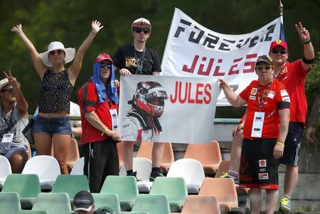 F1 supporters hold a banner in memoriam of former French Formula One driver Jules Bianchi during the first practice session of the Hungarian F1 Grand Prix at the Hungaroring circuit, near Budapest, Hungary July 24, 2015. The popular Bianchi died in hospital last Friday, nine months after his Marussia car slammed into a recovery tractor at the Japanese Grand Prix. REUTERS/Laszlo Balogh