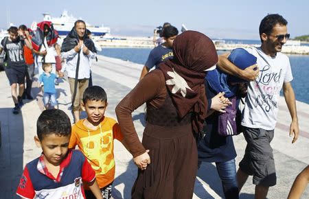 Syrian migrants walk on the shore in Cesme, near the Aegean port city of Izmir, Turkey, August 11, 2015. REUTERS/Osman Orsal