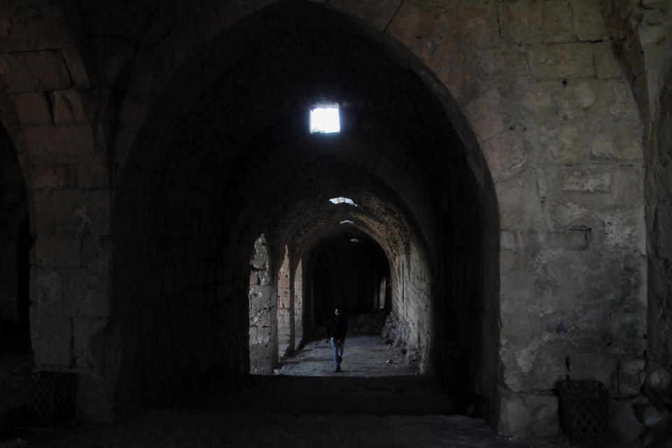 A man walks on a corridor of the Crac des Chevaliers as Syrian troops take reporters on a tour a day after Syrian troops ousted rebels from the castle located near the village of Hosn, Syria, Friday, March 21, 2014. The Syrian army ousted rebels from the massive Crusader fortress after several hours of fierce fighting, killing at least 93 of them as they fled to neighboring Lebanon, an army commander told reporters on a government-led tour of the area Friday. (AP Photo)