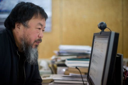 Chinese artist Ai Weiwei sits at a computer at his Beijing office in April 2012. The dissident artist has accused Chinese authorities of trying to "crush him" after he was barred from a hearing challenging a multi-million-dollar tax penalty against a firm he founded