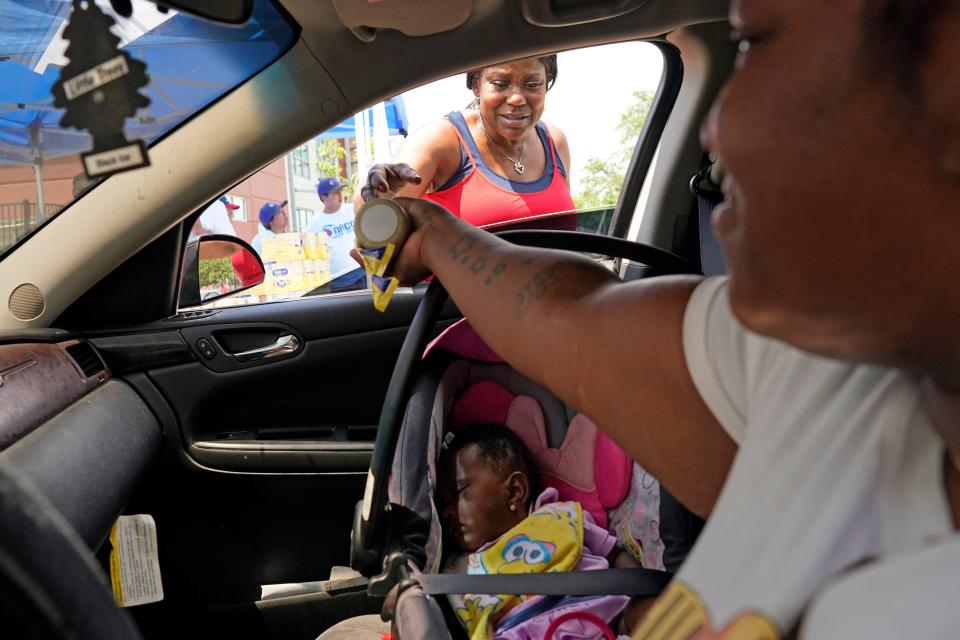 Katherine Gibson-Haynes, top, helps distribute infant formula during a baby formula drive May 14, 2022, in Houston, Texas. Parents seeking baby formula are running into bare supermarket and pharmacy shelves in part because of ongoing supply disruptions and a safety recall.