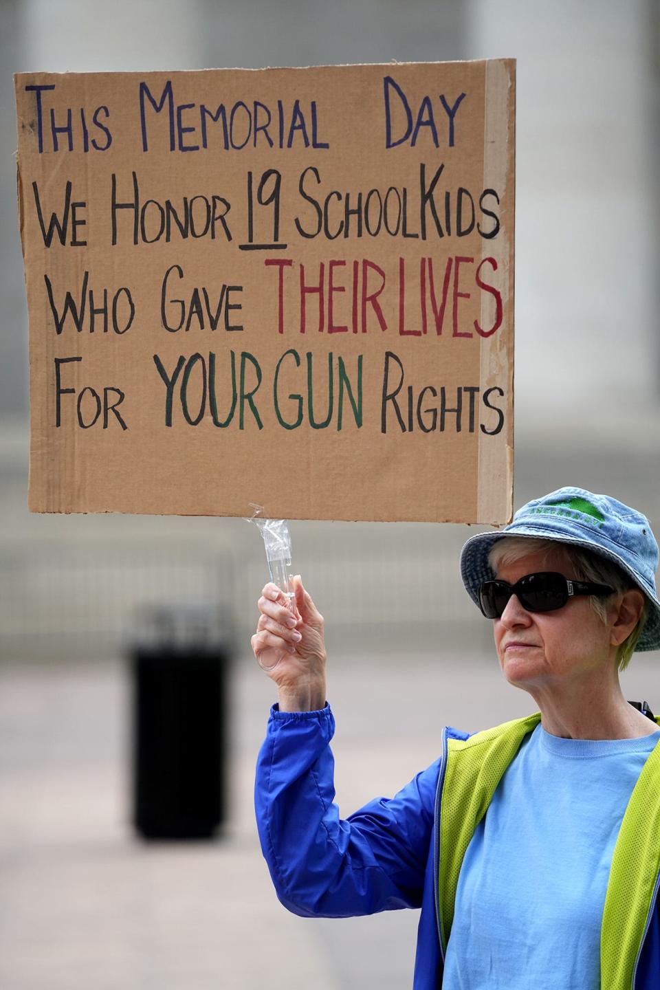 Debra Saunders, of Dublin, holds a sign on May 28 at the Ohio Statehouse during a vigil for the 19 students and two teachers killed at Robb Elementary School in Uvalde, Texas.