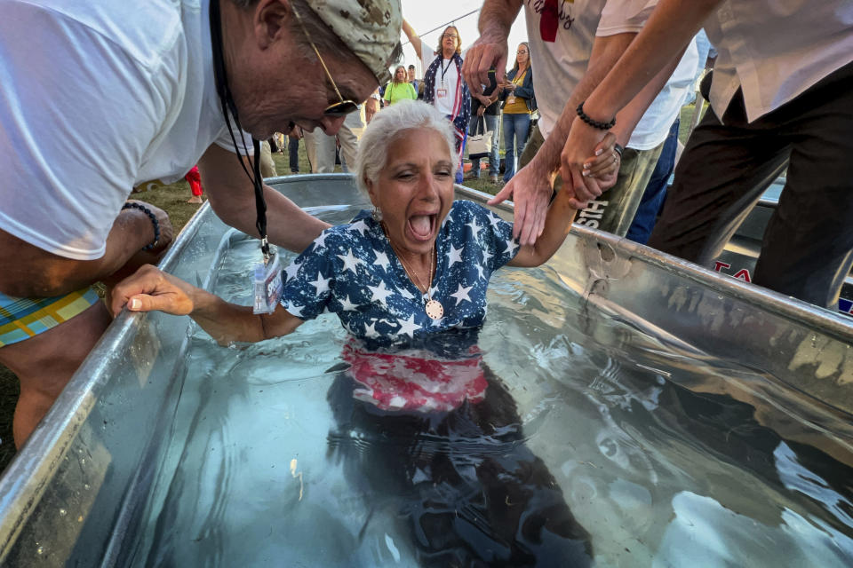 Una mujer es bautizada durante la gira ReAwaken America en la iglesia Cornerstone de Batavia, Nueva York, el 12 de agosto de 2022. Según la versión de la gira ReAwaken presentada en Estados Unidos, el cristianismo está en el centro de la vida y las instituciones estadounidenses, está bajo ataque y sus fieles deben luchar para restaurar y proteger las raíces cristianas de la nación. (AP Foto/Carolyn Kaster)