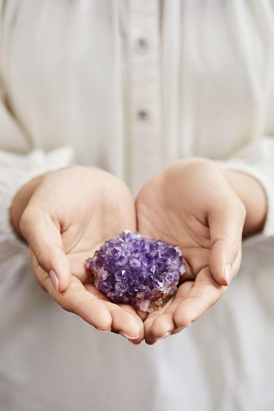 holding purple crystals in hands