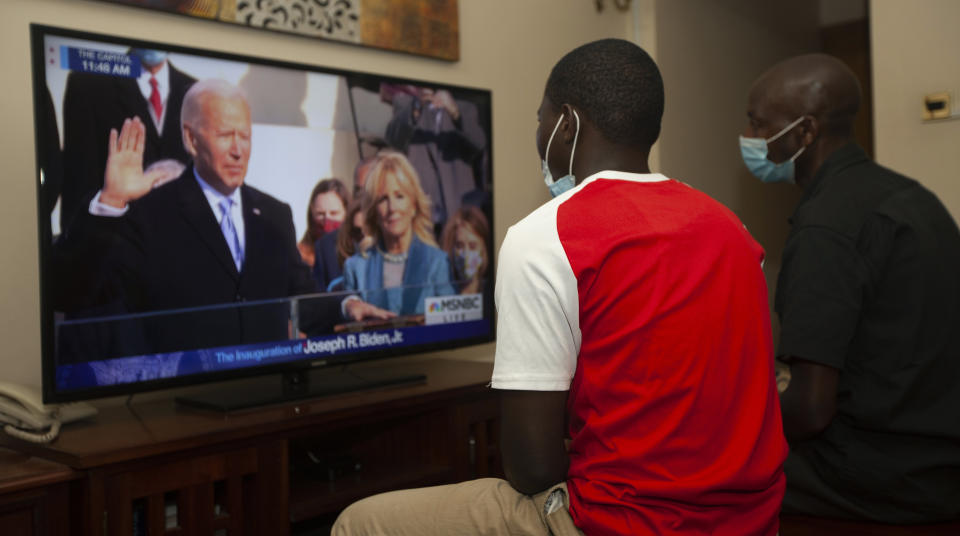 Kenyans watch President-elect Joe Biden's inauguration on the television, in Nairobi, Wednesday, Jan. 20 2021. Biden has officially become the 46th president of the United States. (AP Photo/Sayyid Abdul Azim)