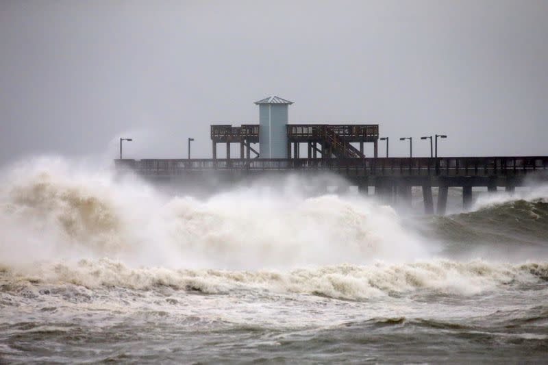 Waves crash along a pier as Hurricane Sally approaches in Gulf Shores