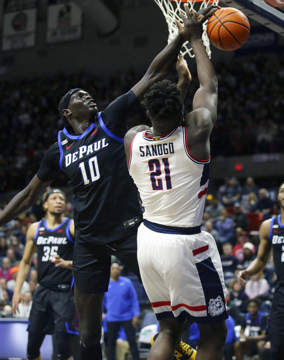 DePaul's Yor Anei (10) blocks a shot by Connecticut's Adama Sanogo (21) during the first half of an NCAA college basketball game Saturday, March 5, 2022, in Storrs, Conn. (AP Photo/Stew Milne)