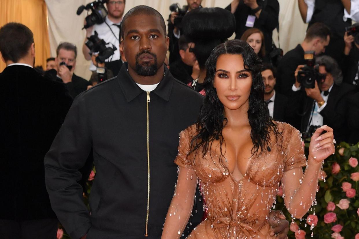 Kanye, pictured with wife Kim, has been finally named a billionaire by Forbes Magazine: AFP via Getty Images