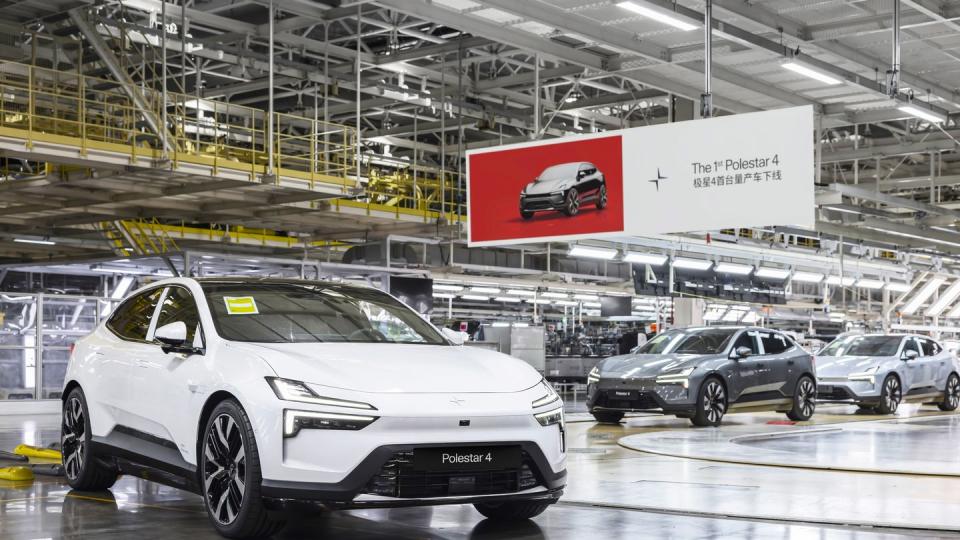 a group of cars parked in a large room with a large screen