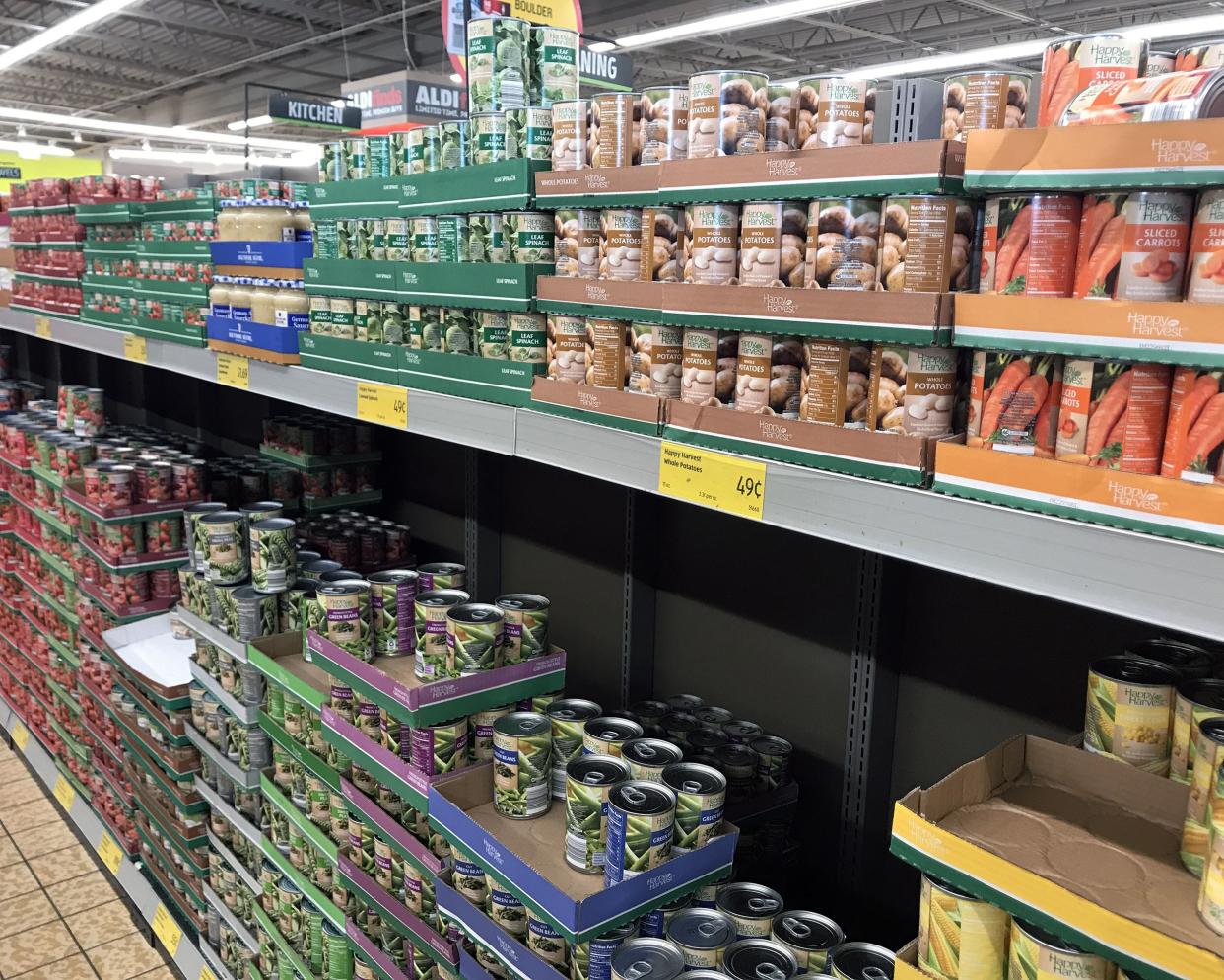 2 rows of several canned foods at an Aldi store in a side of an aisle, clean and organized