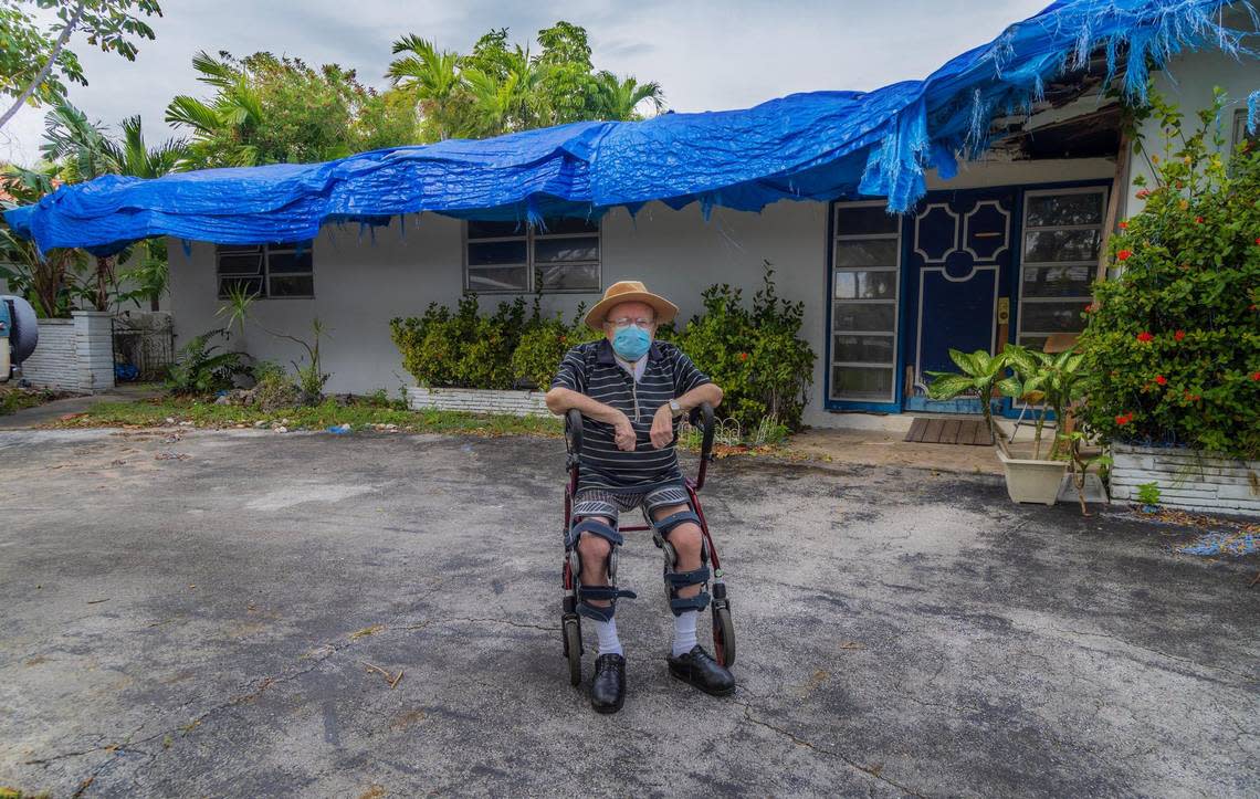 Kenneth Heller, 78, sits on a walker in front of his house in North Miami. Blue tarp covers the entire roof, which is almost 40 years old and in bad shape. Pedro Portal/pportal@miamiherald.com