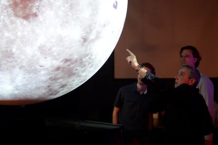 University of Colorado Boulder director of NASA/NLSI Lunar University Network for Astrophysics Research Burns points out locations on a lunar globe to NPP senior fellow Rapetti and PhD student Bassett at the Fiske Planetarium