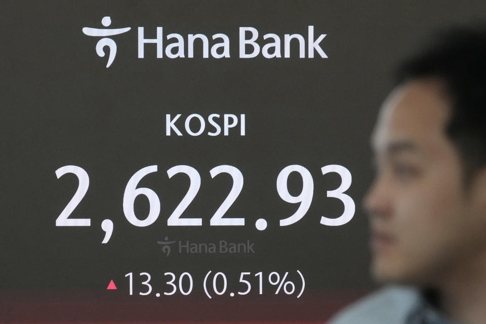 A currency trader passes by the screen showing the Korea Composite Stock Price Index (KOSPI) at the foreign exchange dealing room of the KEB Hana Bank headquarters in Seoul, South Korea, Wednesday, April 17, 2024. (AP Photo/Ahn Young-joon)