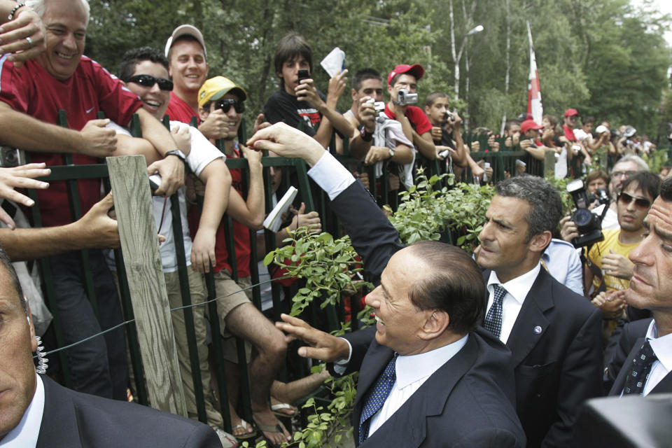 FILE - AC Milan's President Silvio Berlusconi waves to fans at the Milanello training facility, in Carnago, Italy, on July 23, 2007. From his grand entrance by helicopter after buying AC Milan to empowering Monza up to Serie A for the first time in its history, Silvio Berlusconi dominated Italian soccer for decades just like he commanded the show in Italian politics. Berlusconi, a former three-time Italian premier, died Monday, according to his television network. He was 86. (AP Photo/Luca Bruno, File)