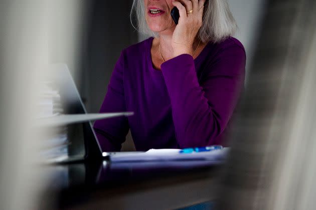 PRODUCTION - 01 October 2021, Bavaria, Munich: A woman sits at a dining table at home and talks on the phone. In front of her is a laptop. (to dpa 