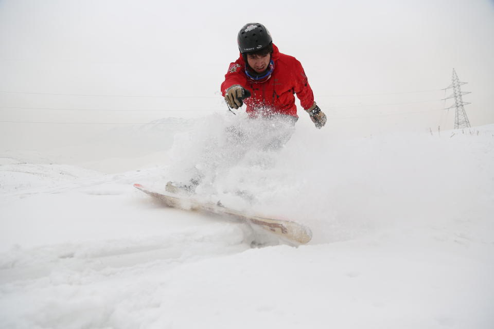 In this Friday, Jan. 24, 2020 photo, Mohammad Farzad, 20, a member of the Afghanistan Snowboarding Federation practices session on the snow-covered hillside known as Kohe Koregh, on the outskirts of Kabul, Afghanistan. While Afghanistan’s capital may seem an unlikely destination for snowboarders, a group of young Afghans is looking to put the city on the winter sports map and change perceptions about their war-weary nation. (AP Photo/Tamana Sarwary)