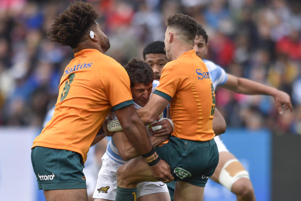 Argentina's Tomas Cubelli, center, is tackled by Australia's Nic White, right, and Australia's Rob Valetini, during their rugby championship match in Mendoza, Argentina, Saturday, Aug. 6, 2022. (AP Photo/Gustavo Garello)