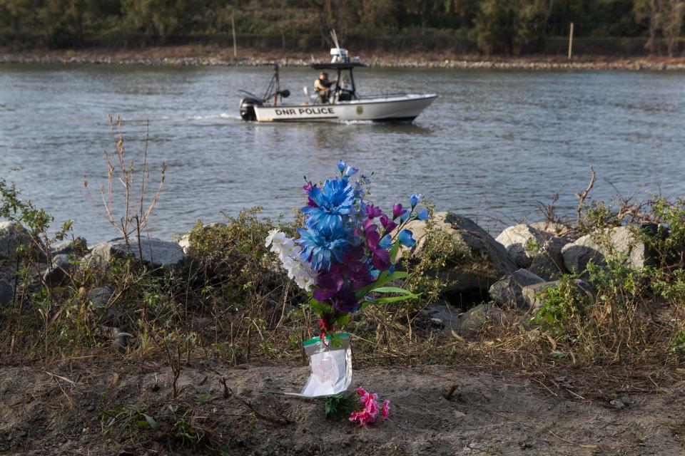 Flowers and a handwritten note of sympathy sit on the edge of the Chesapeake & Delaware Canal as a DNREC Fish & Wildlife Natural Resources Police boat searches for 6-year-old Ethan Lindsey on Monday afternoon. Lindsey's body was found Thursday morning.