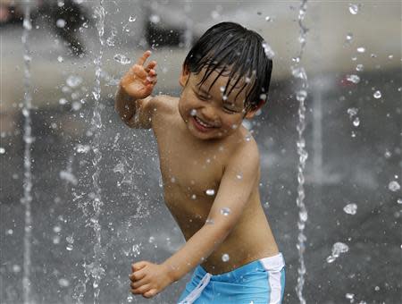 Un niño se refresca del calor en una fuente en Tokio, jul 13 2013. El calentamiento global supone una amenaza creciente para la salud, el panorama económico, los recursos hídricos y los alimentos de miles de millones de personas, dijo un informe de destacados científicos que insta a actuar con rapidez para contrarrestar los efectos de las emisiones de dióxido de carbono. REUTERS/Toru Hanai