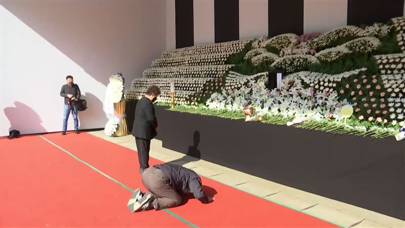 罹難者家屬跪在靈堂前行大禮。（圖／AP授權）